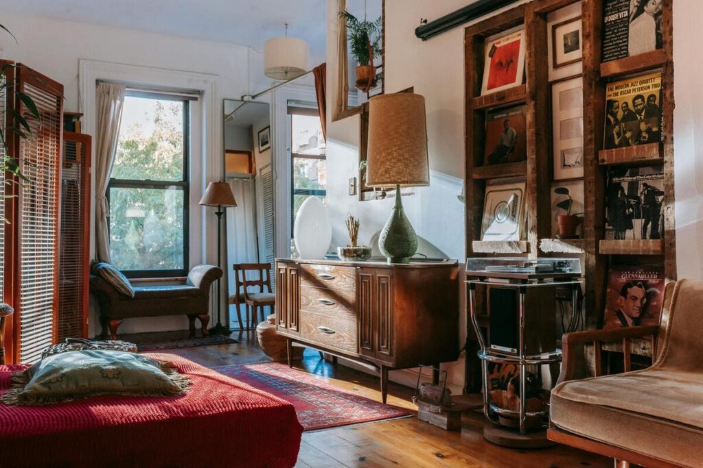 Sala de estar con decoración clásica, muebles de madera, luz natural y vinilos en la pared